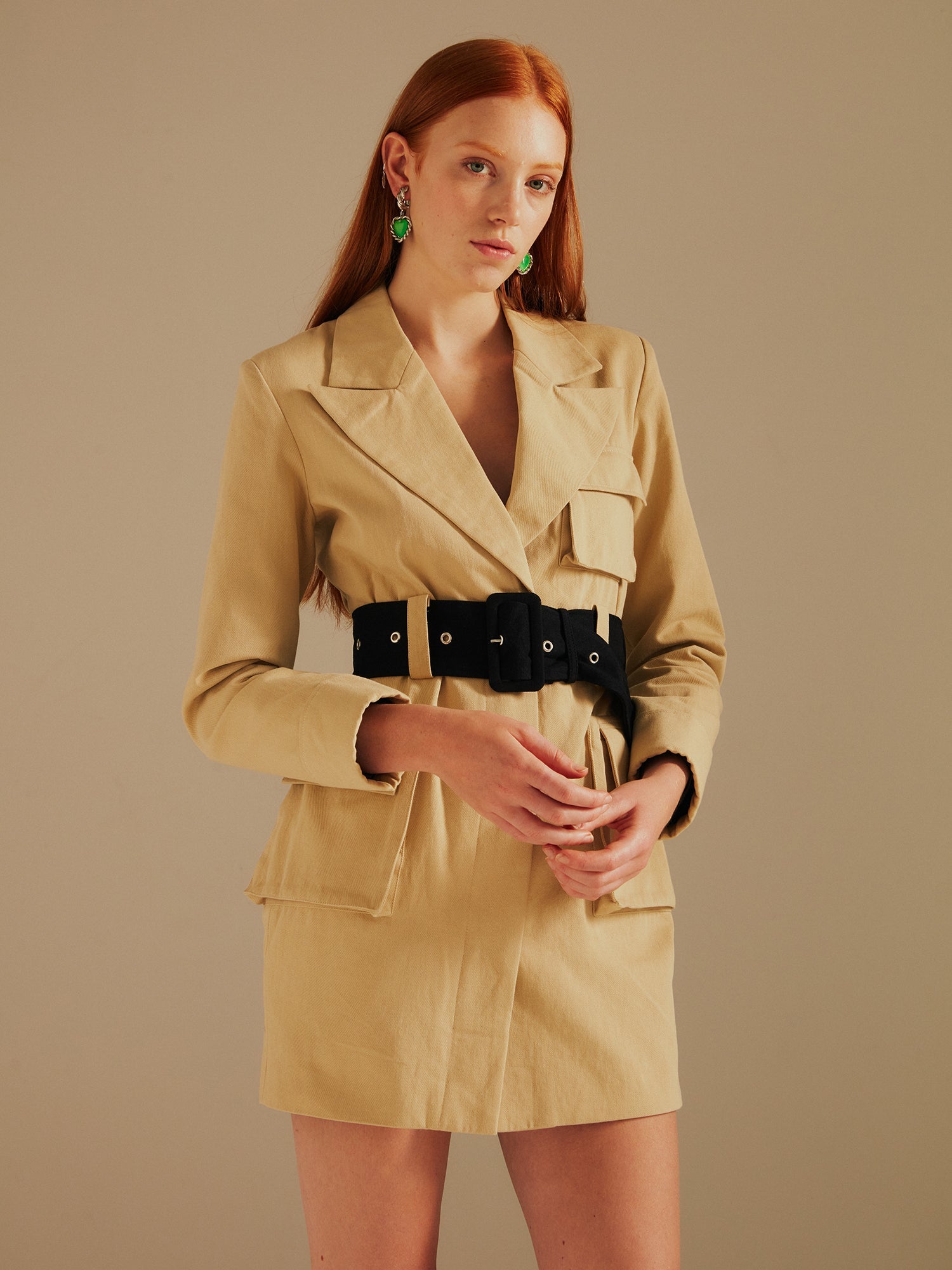 model wears the Ashley Utility Belted Blazer Dress in a cropped image holding her hands in front of her body